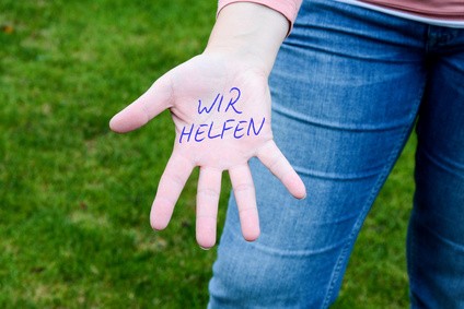 Hand mit Schrift "Wir helfen"