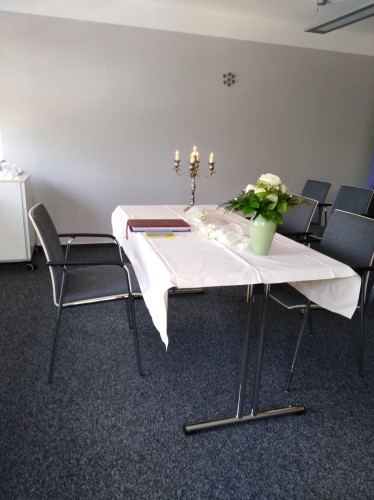 Kleiner Trausaal im Obergeschoss des Rathauses mit einem Tisch mit wei&szlig;er Tischdecke, Blumen und Kerzen