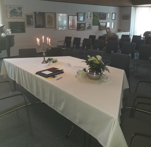 Trausaal im Ratssaal mit Tisch mit wei&szlig;er Tischdecke, Stammbuch, Kerzen und Blumen