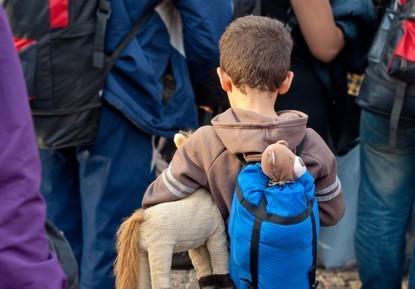 Junge auf der Flucht mit Rucksack und Kuscheltier