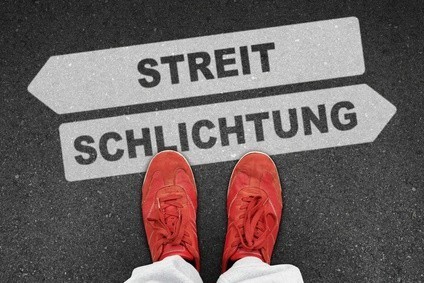Rote Schuhe vor Schilder mit Streit und Schlichtung