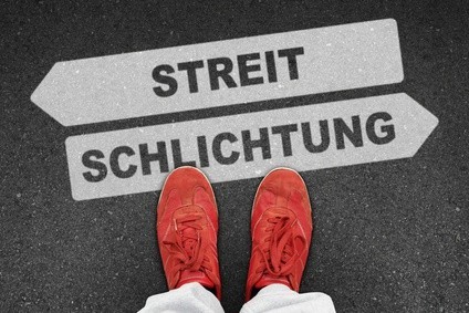 Rote Schuhe vor Schilder mit Streit und Schlichtung