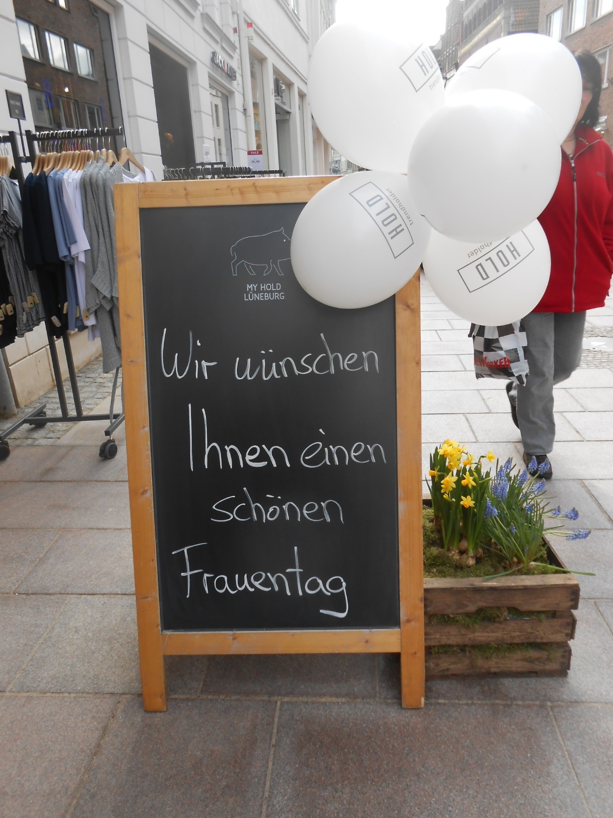 Aufsteller mit der Aufschrift "Wir w&uuml;nschen Ihnen einen sch&ouml;nen Weltfrauentag"