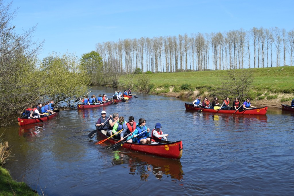 Jugendliche paddeln in Kanus auf der Hunte